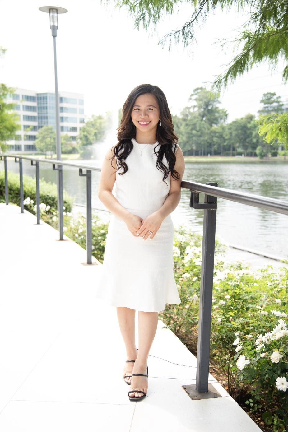 Cherry Lim smiling by the water in a white dress