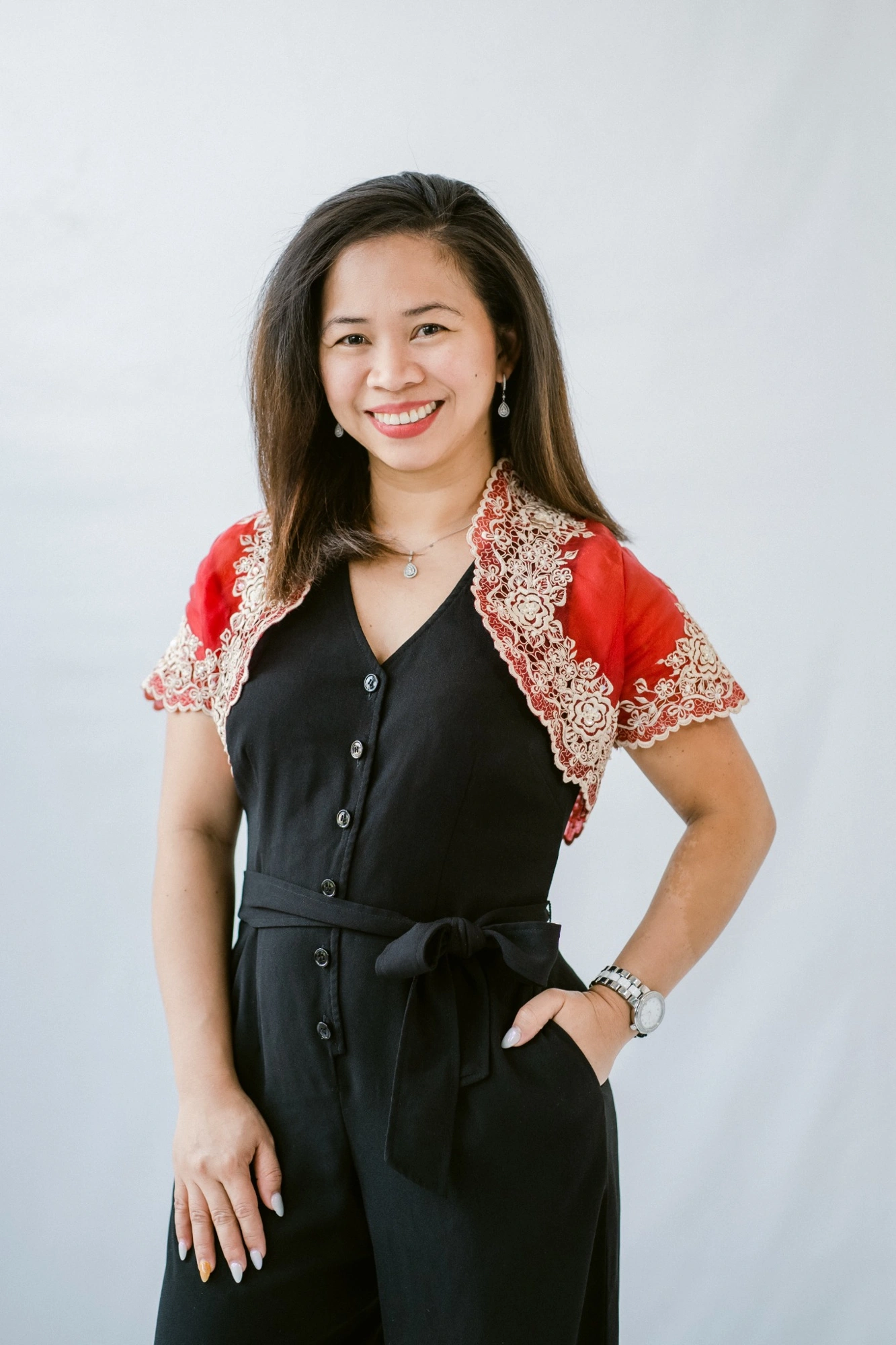 Cherry Lim smiling in a black outfit with a red embroidered layer
